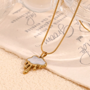 Detailed macro view of gold cloud necklace with shell texture on a beige background