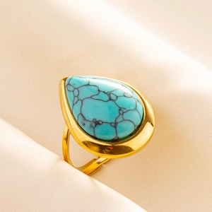 Close-up of a drop-shaped turquoise gemstone set in an adjustable golden steel ring band