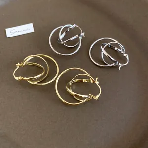 Minimalist interwoven triple hoop earrings in polished gold and silver metal finishes