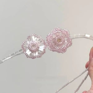 Double-layered beaded necklace with pink and white crystal flower pendants in soft light