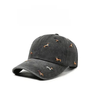 Detail of embroidered dachshund patterns on a vintage washed grey baseball cap