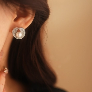 Gros plan de boucles d'oreilles perles avec anneaux argentés sur l'oreille du mannequin