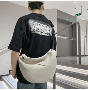 Rear view of cream crossbody crescent bag showing its large capacity and wide strap