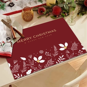 Festive red linen Christmas placemat with gold lettering and white snowflake patterns