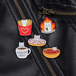 Detail of five enamel cat pins featuring fries and donuts on a black leather jacket