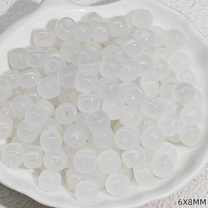 Macro shot of 6x8mm translucent white drum beads for DIY jewelry making and craft projects
