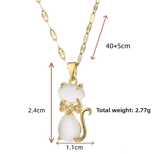 Detailed close-up of golden cat pendant with white opal stones and sparkling bow tie detail