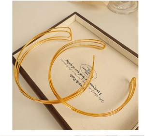 Close-up of minimalist gold multilayer open cuff bracelet in a vintage French display tray