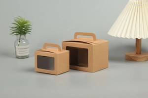 Detail of kraft paper gift boxes with clear window and handles on a minimalist desk