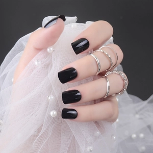 Glossy black short square fake nails paired with silver ring set on mesh background