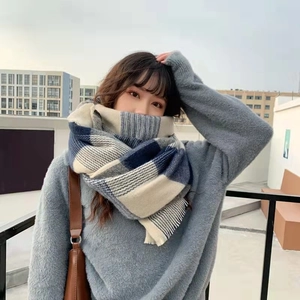 Blue and beige plaid cashmere-feel winter scarf with tassels worn by model outdoors