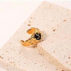 Detail shot of golden hammered ring featuring a faceted black zircon on stone base