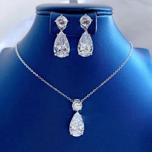 Macro shot of 925 silver teardrop jewelry set featuring clear zircon inlay on blue stand