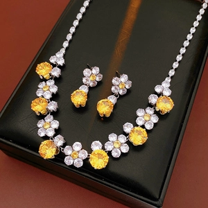 Close-up of sparkling yellow zircon flower necklace and earrings set in a black jewelry box