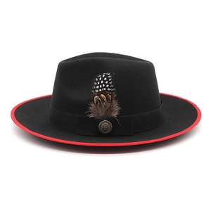 Detail of black wool fedora featuring red bound edge, feather trim, and vintage gold buckle