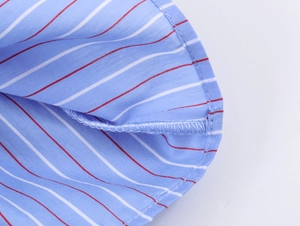Détail macro du motif nid d'abeille et des coutures d'ourlet sur une chemise bleue à manches