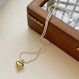 925 silver heart pendant necklace in gold finish on a minimalist jewelry box