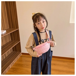 Detailed close-up of a pink quilted crossbody bag for kids shown on a child model