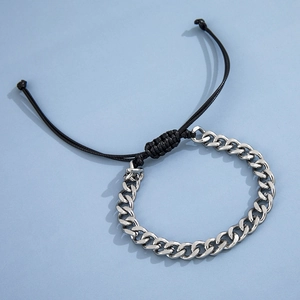 Detail of silver stainless steel horsebit chain merged with black braided cord on blue