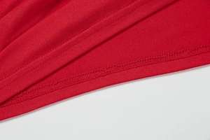 Detail of red off-shoulder dress showing high-quality double-needle stitching and seams