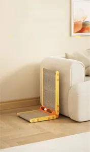 L-shaped cat scratching board with built-in ball toy track next to a cream sofa