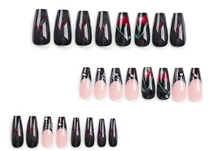 Detail of coffin-shaped press-on nails with dark rose, flame, and cherry designs