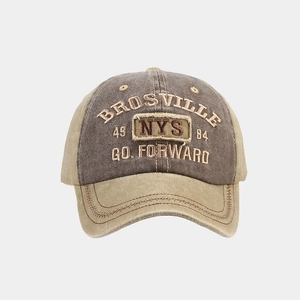 Detail of vintage washed baseball cap featuring contrast stitching and heavy embroidery