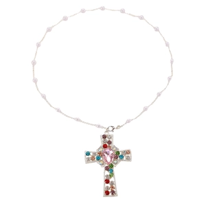 Macro shot of pearl necklace featuring a silver cross pendant with colorful rhinestones