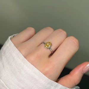 Close-up of a hand wearing an S925 silver ring with a yellow oval ice-cut gemstone