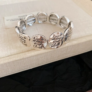 Detail of vintage silver engraved religious bracelets with inspirational scripture text
