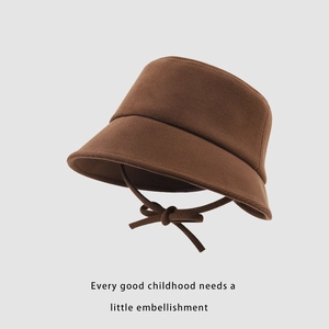 Détail d'un chapeau cloche en tricot marron pour enfant avec nœud décoratif