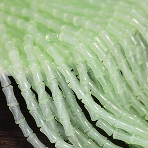 Detailed view of light green bamboo-shaped glass beads for DIY jewelry making