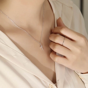 Close-up of elegant S925 sterling silver cross pendant necklace and sleek ring on model