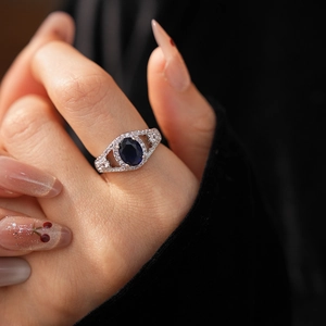 Detail of vintage silver ring featuring a deep blue oval zircon with a double-arm band