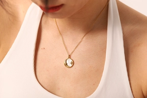 Détail du collier plaqué or 18k avec pendentif lune et étoile et incrustation de nacre blanche