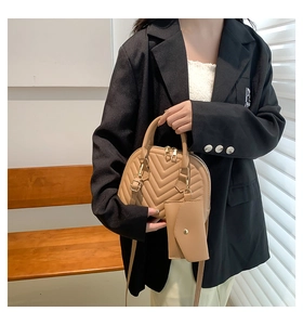 Détail du sac coquille beige avec matelassage en V et sa mini pochette enveloppe assortie
