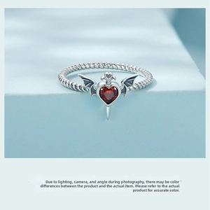 Macro view of gothic S925 silver ring with red heart stone and dark wing accents