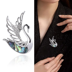 Elegant silver swan brooch with colorful abalone shell and sparkling crystals on lapel