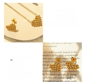 Close-up of gold plated titanium heart beaded necklace and matching stud earring set