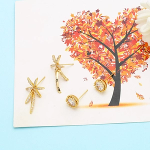 Vintage gold star drop earrings and classic round zircon studs on a decorative card