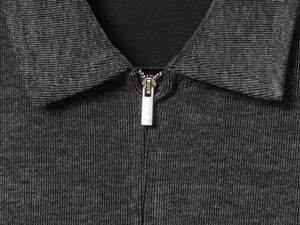 Detailed macro view of the dark grey ribbed fabric and metal zipper collar mechanism