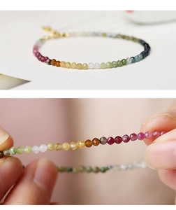 Macro shot of 2mm rainbow tourmaline beads with faceted texture and golden clasp
