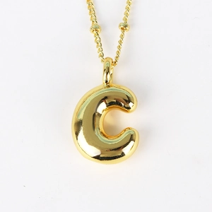 Macro shot of gold-plated hip-hop letter C pendant with reflective metallic finish