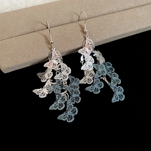 Détail de boucles d'oreilles papillon à pampilles avec finition métal dégradé bleu