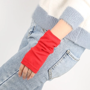 Macro shot of red ribbed knit arm warmers showing texture and elastic wrist cuffs