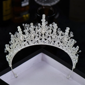 Detailed close-up of a silver crystal bridal crown with floral leaf patterns in a display box