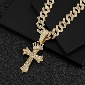 Vue détaillée du pendentif croix couronne dorée avec chaîne cubaine sur boîte noire