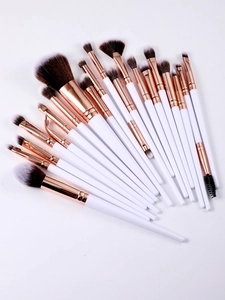 Flat lay of 20pcs white and rose gold professional makeup brush set for face and eyes