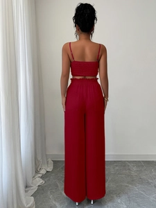 Vista posteriore del completo rosso due pezzi con top a pieghe e pantaloni larghi a vita alta