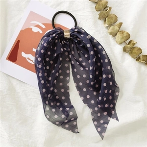 Detailed shot of dark blue polka dot chiffon hair tie with elegant gold buckle hardware